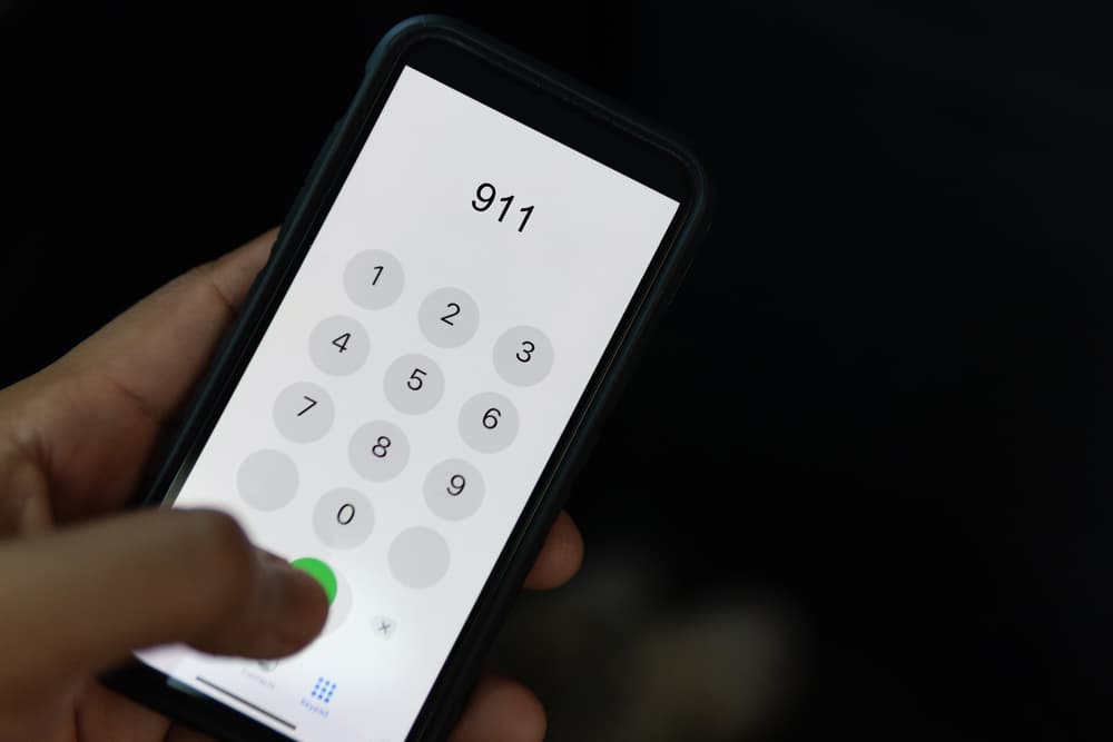  A person holding a cell phone displaying the number 911, emphasizing emergency contact after a car accident in Illinois.