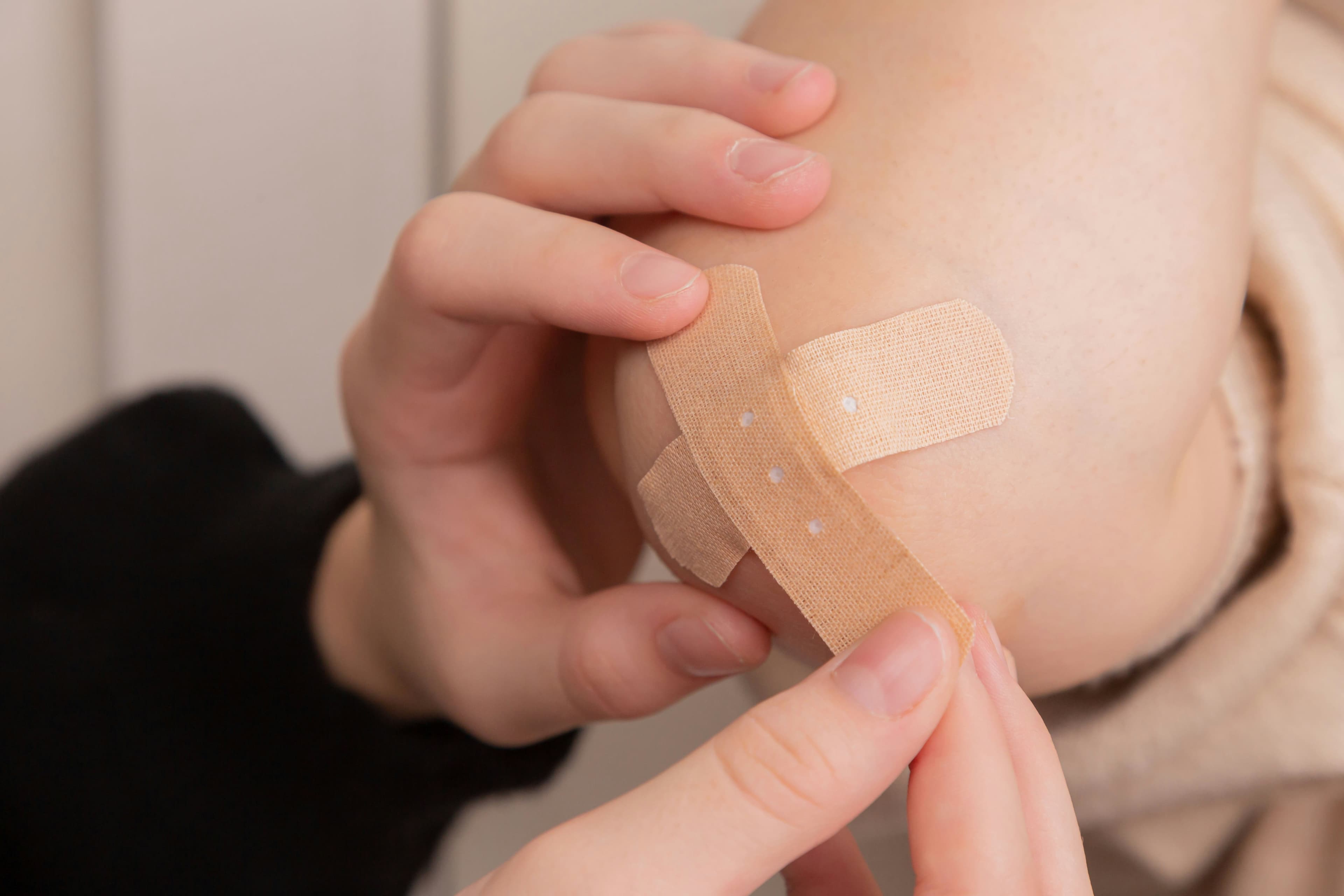 A person applying bandages to another person's arm after a slip-and-fall incident in Wisconsin.